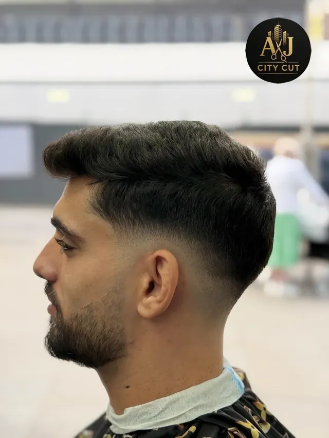 A textured cut with a skin fade and a beard